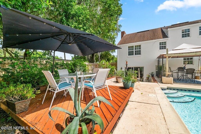 exterior space featuring a gazebo, fence, outdoor dining area, and an outdoor pool