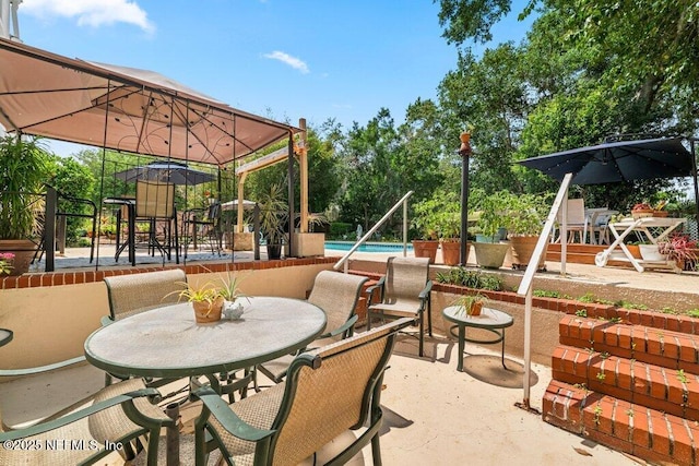view of patio featuring outdoor dining area and an outdoor pool