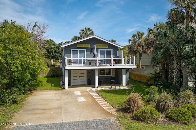 2740 Loja St, Saint Augustine, FL 32084 - coastal inspired home with a deck, french doors, a front yard, concrete driveway, and an attached garage