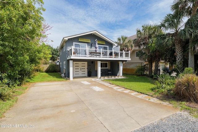 2740 Loja St, Saint Augustine, FL 32084 - coastal home with a patio, a wooden deck, a front yard, concrete driveway, and an attached garage