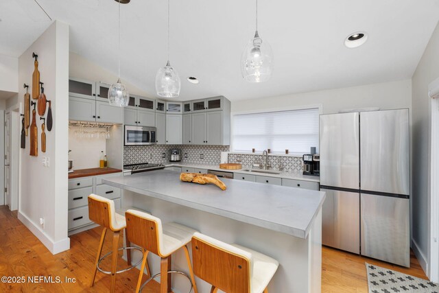 2740 Loja St, Saint Augustine, FL 32084 - kitchen featuring stainless steel appliances, backsplash, light wood finished floors, and a sink