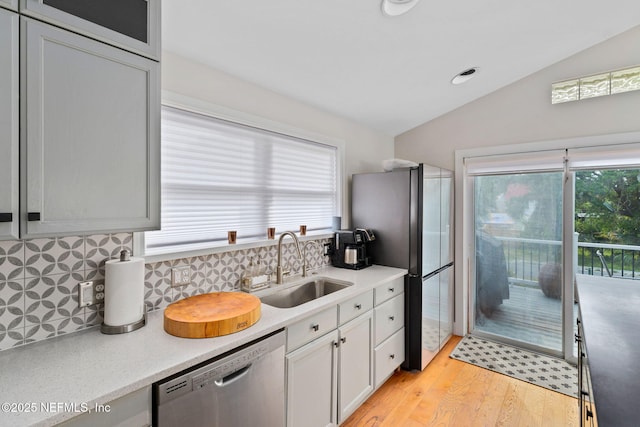 2740 Loja St, Saint Augustine, FL 32084 - kitchen with lofted ceiling, tasteful backsplash, a sink, appliances with stainless steel finishes, and light wood finished floors