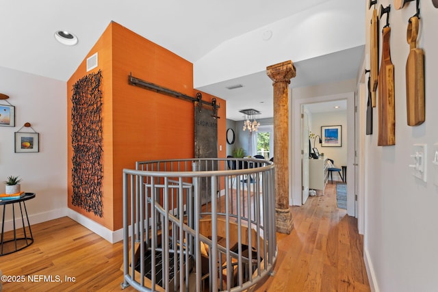 2740 Loja St, Saint Augustine, FL 32084 - hallway with an upstairs landing, a barn door, visible vents, and light wood-style floors