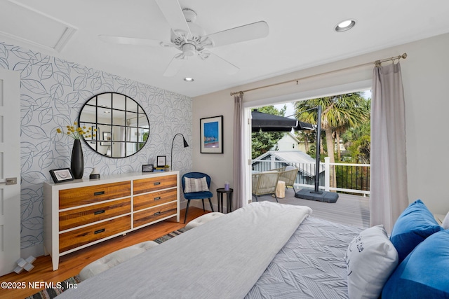 2740 Loja St, Saint Augustine, FL 32084 - bedroom featuring attic access, access to exterior, an accent wall, wallpapered walls, and wood finished floors