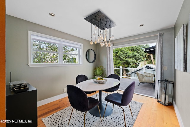 2740 Loja St, Saint Augustine, FL 32084 - dining space featuring baseboards, a wealth of natural light, a chandelier, and light wood-style floors