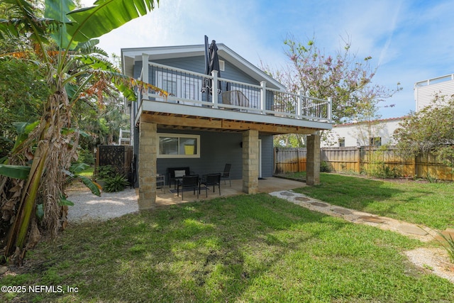 2740 Loja St, Saint Augustine, FL 32084 - back of house featuring a lawn, fence, a wooden deck, and a patio area