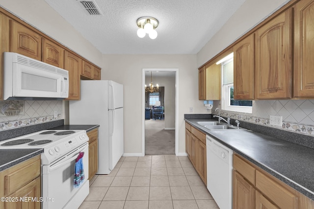 kitchen featuring dark countertops, a sink, white appliances, backsplash, and baseboards
