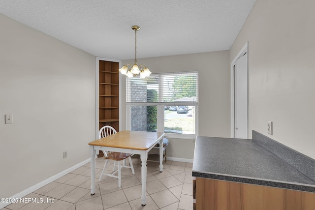 dining room featuring baseboards, a notable chandelier, a textured ceiling, and light tile patterned floors