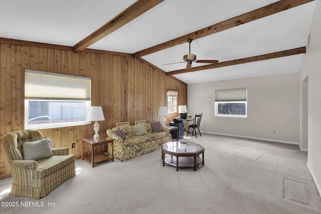 living area featuring ceiling fan, carpet floors, vaulted ceiling with beams, and wooden walls