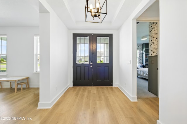 177 Windwalker Dr, Saint Augustine, FL 32092 - foyer featuring light wood-style flooring, a chandelier, baseboards, and a raised ceiling