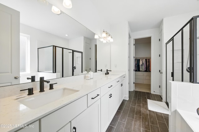 177 Windwalker Dr, Saint Augustine, FL 32092 - full bathroom featuring a shower stall, a walk in closet, double vanity, a garden tub, and wood finish floors