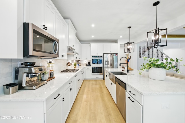 177 Windwalker Dr, Saint Augustine, FL 32092 - kitchen with appliances with stainless steel finishes, a sink, white cabinetry, under cabinet range hood, and recessed lighting
