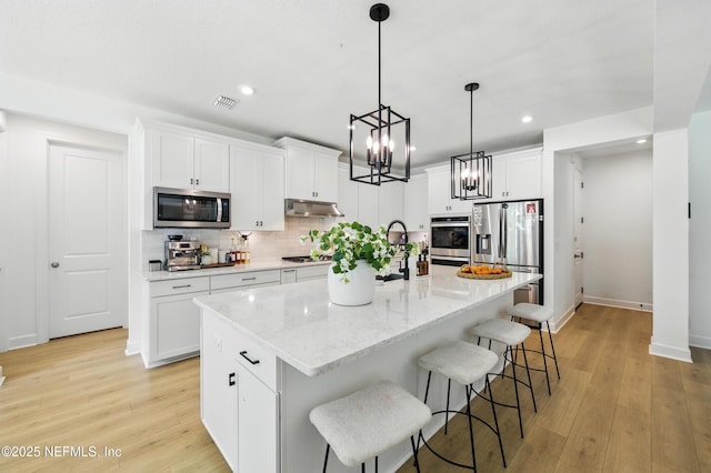 177 Windwalker Dr, Saint Augustine, FL 32092 - kitchen featuring stainless steel appliances, under cabinet range hood, recessed lighting, decorative backsplash, and white cabinets