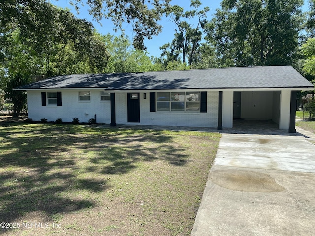 ranch-style house with brick siding, a carport, a front yard, and concrete driveway