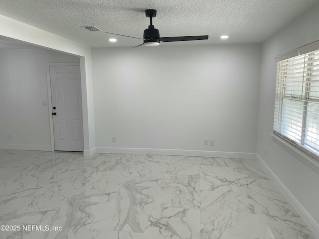 empty room featuring a textured ceiling, plenty of natural light, baseboards, visible vents, and a ceiling fan