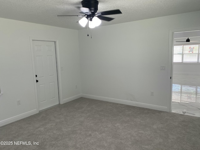spare room featuring a textured ceiling, carpet flooring, and ceiling fan
