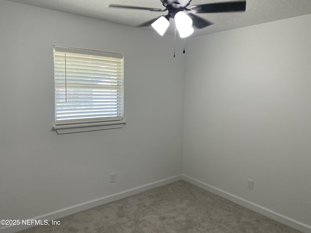 carpeted spare room featuring ceiling fan, baseboards, and a textured ceiling