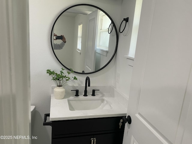 half bathroom featuring vanity and toilet