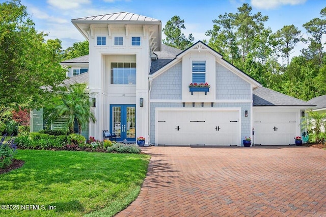 36 Preserve Island Cir, Ponte Vedra Beach, FL 32082 - view of front of property with a front lawn, a standing seam roof, decorative driveway, an attached garage, and french doors