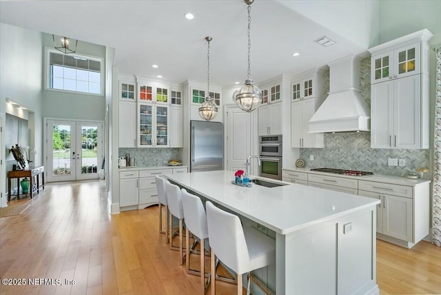 36 Preserve Island Cir, Ponte Vedra Beach, FL 32082 - kitchen featuring an island with sink, appliances with stainless steel finishes, light countertops, and premium range hood