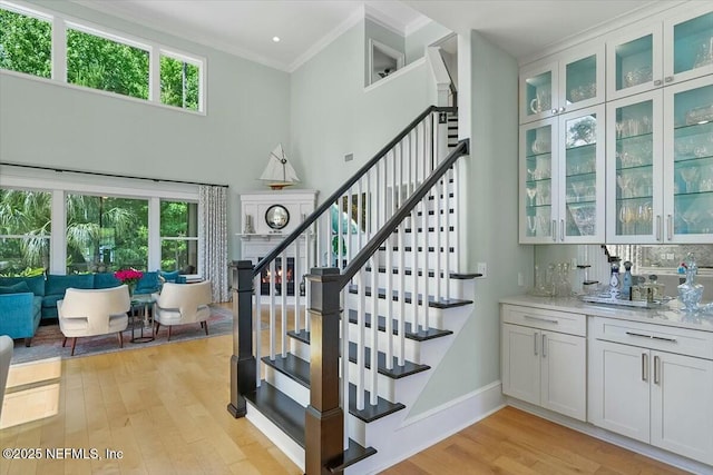 36 Preserve Island Cir, Ponte Vedra Beach, FL 32082 - stairway featuring crown molding, wet bar, baseboards, a towering ceiling, and wood finished floors