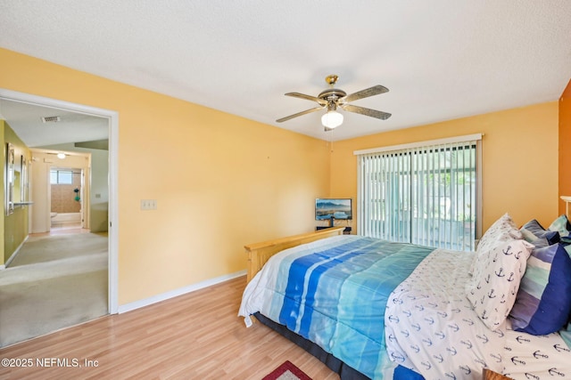 bedroom with a ceiling fan, multiple windows, wood finished floors, and baseboards