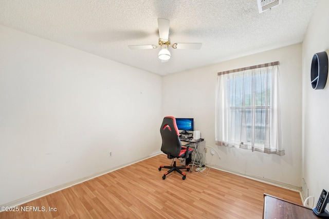 office area with wood finished floors, a ceiling fan, visible vents, and baseboards