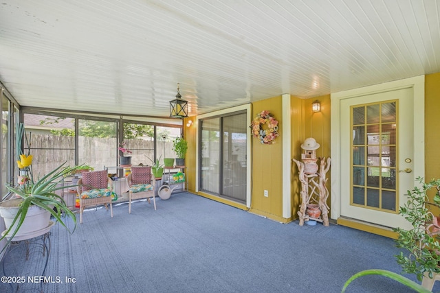 sunroom with carpet and wood ceiling