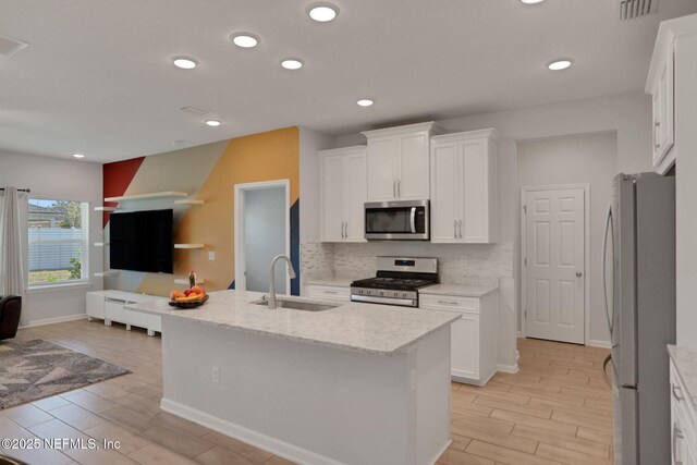 383 Narrowleaf Dr, Saint Johns, FL 32259 - kitchen with a sink, open floor plan, stainless steel appliances, light wood finished floors, and visible vents