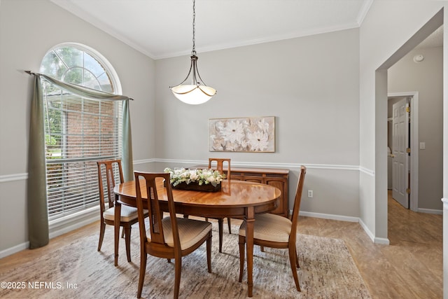 dining space with crown molding and baseboards
