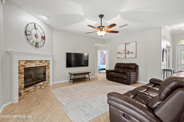 living room with a fireplace, ceiling fan, crown molding, visible vents, and baseboards