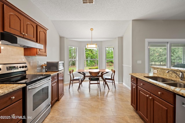 kitchen featuring decorative backsplash, a sink, appliances with stainless steel finishes, under cabinet range hood, and decorative light fixtures