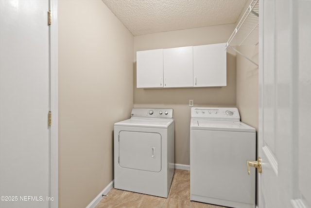 clothes washing area featuring a textured ceiling, cabinet space, independent washer and dryer, and baseboards
