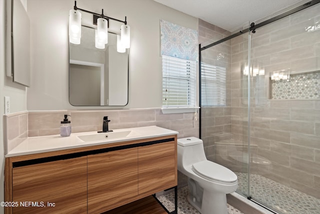 full bath featuring toilet, tile walls, a shower stall, and vanity