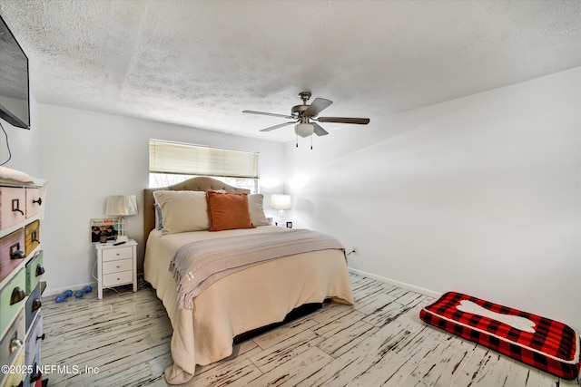 bedroom featuring baseboards, a ceiling fan, a textured ceiling, and wood finished floors