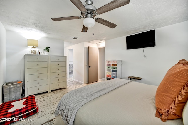 bedroom with a textured ceiling, ceiling fan, wood finished floors, and visible vents