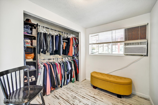 spacious closet featuring cooling unit and wood finished floors