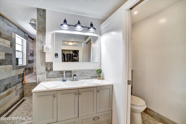 full bathroom featuring a walk in shower, toilet, and vanity