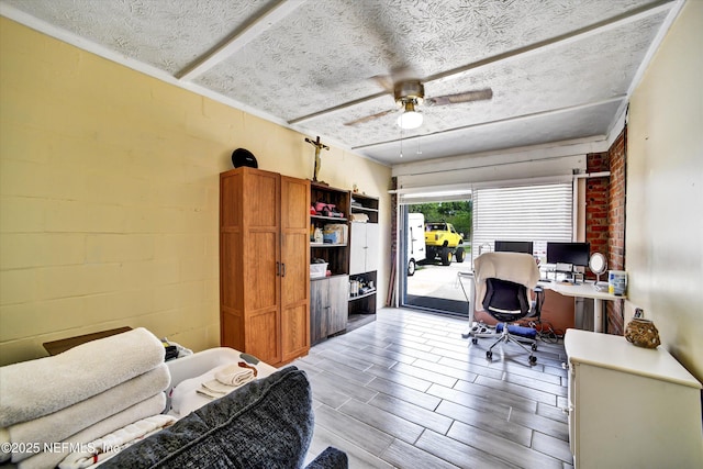 office area with a textured ceiling, ceiling fan, and light wood-style floors