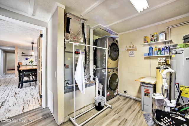 interior space featuring a textured ceiling, laundry area, wood finished floors, and stacked washer and clothes dryer