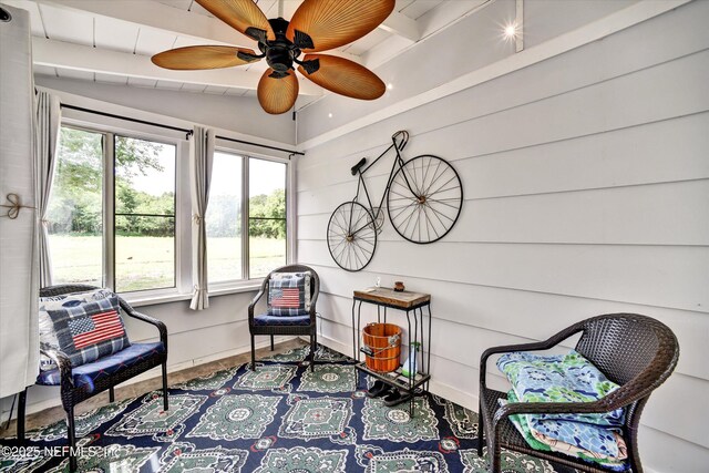 living area with a ceiling fan and vaulted ceiling