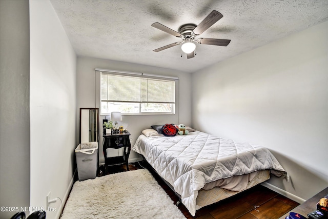 bedroom with baseboards, a ceiling fan, a textured ceiling, and wood finished floors