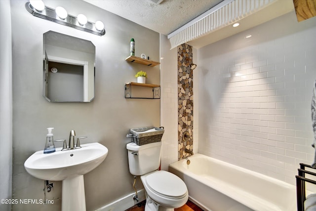 full bathroom featuring toilet, a textured ceiling, and shower / washtub combination