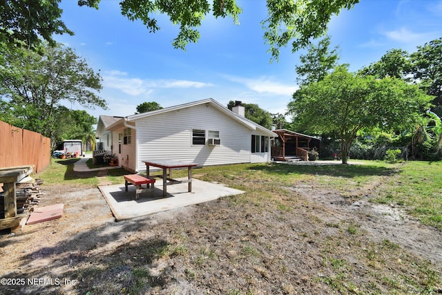rear view of house with a yard, fence, a chimney, and a patio area