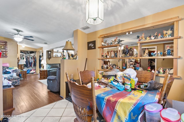tiled dining space with visible vents and ceiling fan