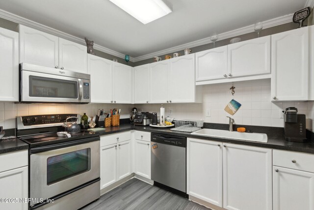 30936 Paradise Commons Unit 221, Fernandina Beach, FL 32034 - kitchen with white cabinetry, dark countertops, appliances with stainless steel finishes, and a sink