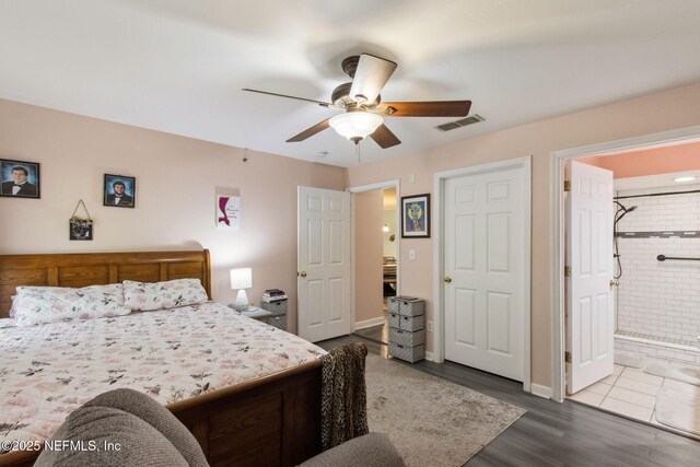 30936 Paradise Commons Unit 221, Fernandina Beach, FL 32034 - bedroom with dark wood-style floors, a ceiling fan, visible vents, baseboards, and ensuite bathroom