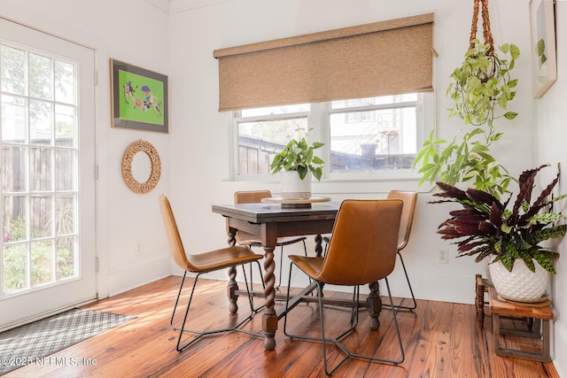 dining space featuring baseboards and wood finished floors