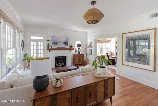 living area featuring visible vents, ornamental molding, and plenty of natural light