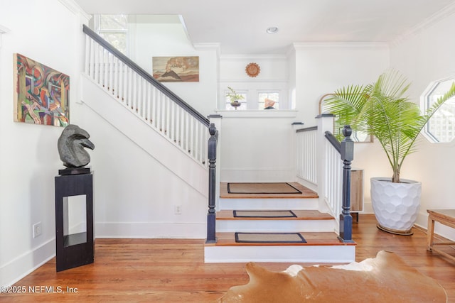 stairway with baseboards, ornamental molding, and wood finished floors